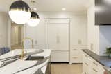 Plentiful cabinet storage in a classic white brings balance to the dramatic kitchen.