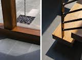 Chain downspouts empty into a river rock drainage bed, and reclaimed wood treads are used in a minimally detailed open stair.
