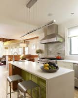 In the kitchen, accents of vibrant green, golden yellow and earthy brown reference shades seen in the garden beyond.