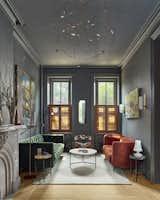 A formal parlor space, typical of townhouses of this era, is divided into two zones flanking the original marble fireplace - a sitting area on one side and an audio zone on the other.