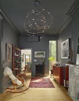 A formal parlor space, typical of townhouses of this era, is divided into two zones flanking the original marble fireplace - a sitting area on one side and an audio zone on the other.