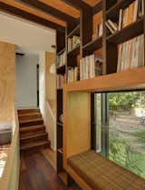 Mezzanine library with stairs leading up to bedroom and bathroom