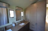 The guest bath was wrapped in cabinets and storage by rifugio mixing two complimentary finishes
