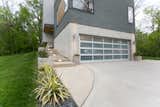 Exterior side shot showing concrete work and how the home is cut into the side of the hill.