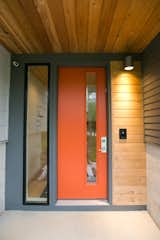 Mod-century modern inspired front door in a pop of orange against a two-toned grey exterior  Photo 3 of 23 in The Sangar House by Mod Abode by Jamie Sangar