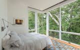 Bedroom, Medium Hardwood Floor, Bed, and Wall Lighting View into tree tops outside main bedroom  Photo 8 of 21 in Konomore House by Charles Rose Architects