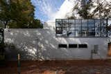 The rear of the garage building with its greenhouse on the upper floor abuts the end of an alley