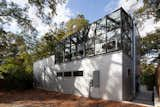 The rear of the garage building with its greenhouse on the upper floor abuts the end of an alley