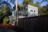 The rear of the garage building with its greenhouse on the upper floor abuts the end of an alley