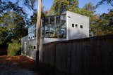 The rear of the garage building with its greenhouse on the upper floor abuts the end of an alley