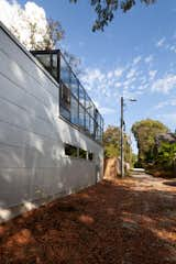 The rear of the garage building with its greenhouse on the upper floor abuts the end of an alley