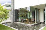 Summit House Beverly Hills luxury home modern glass wall dining room with outdoor pond water feature