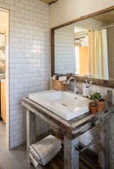 Bathroom Vanity. Salvaged from Blacksmith workshop bench. Original window frame used for mirror. Subway tile interior. 