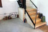 Living Room, Bookcase, and Concrete Floor Plywood Stair Landing with Storage Below  Photo 4 of 13 in Blacksmith Shop by Design Platform