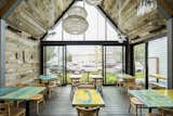 Interior of expansion looking to the street. Exposed steel structure with reclaimed snow fence cladding. Custom painted tables by Platform Workshop. 