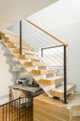 The design of the staircase was carefully thought through to maximize space below, keep the light from an existing outside window, and create an additional element of warmth. The owners had a baby shortly after moving into their new home, and a temporary baby gate was added for the little ones safety. 