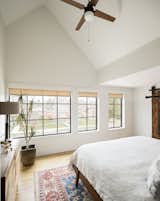 Master Bedroom with vaulted ceiling and western views to mountain and nearby lake. While the footprint of the house is modest, and the ability to vault the ceilings makes the spaces feel larger then they are. A crisp white was used on wall, trim, and ceilings to allow natural elements like the floors, doors, plants, rugs, and furniture provide the vibrancy. 