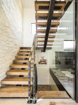 New steel and maple butcherblock staircase. Floor to ceiling glass. Stone wall. 