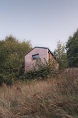 The structures blend softly into the site.   Photo 5 of 19 in Cabin on the Vistula by Nate Cook Photography