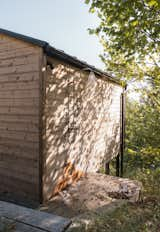 Dappled light flows over the sauna's exterior shower. 