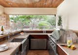 Ipe clad custom outdoor kitchen with stainless steel cabinetry inserts by Lynx, with Lynx natural gas grill, with Cesarstone counters in linen. Bar top is local sandstone and barstools are by Janus Et Cie.
