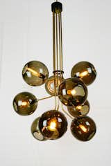 This grand pendant named "Tree of Light", comprised of 9 mouth blown glass spheres. Suspended via custom made brass branches. Also available in fewer branches and as a floor lamp.
