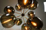 This grand pendant named "Tree of Light", comprised of 9 mouth blown glass spheres. Suspended via custom made brass branches. Also available in fewer branches and as a floor lamp.
