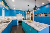 Kitchen, Limestone Floor, Colorful Cabinet, and Pendant Lighting Located in Park Ridge, Illinois, this kitchen renovation gives new life to a midcentury that has been passed down through generations.  Photos from Beauty in Blue Park Ridge