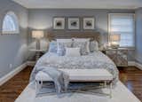 Coastal-inspired master bedroom with neutral shades of blue and beige, mixed lighting, and layered elements create an inviting, relaxing space.  Photo 9 of 14 in East End Home Redesign by Debra Gildersleeve