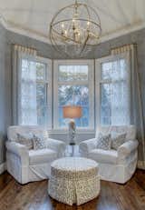 A cozy corner of the master bedroom with a lot of natural light, and delicately beautiful chandelier for added warmth.   Photo 10 of 14 in East End Home Redesign by Debra Gildersleeve