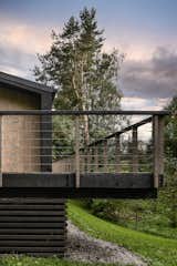 Outdoor, Garden, Wood Patio, Porch, Deck, Wood Fences, Wall, Horizontal Fences, Wall, and Side Yard The external railings are made of wood and a metal cable  Photo 9 of 30 in Modular house on the slope by Ivan Ovchinnikov