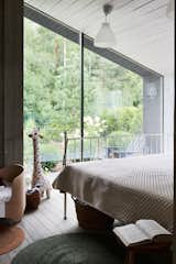 Bedroom, Bed, Medium Hardwood Floor, Ceiling Lighting, and Light Hardwood Floor The back of the house, where the bedrooms are situated, is oriented towards the forest  Photo 14 of 30 in Modular house on the slope by Ivan Ovchinnikov