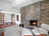 A fireplace made with stacked natural stone and a coordinating granite hearth is the focal point of the entry and living room.