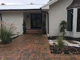 We updated the entrance with double doors, painted black, and landscaping (still in transition). We are still debating the red brick walk and retaining walls.  The black gutters were a nice accent on the white brick. 