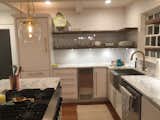 Updated kitchen. We used lots of white with metallic accents (both silver and gold). We kept the original Viking stove-top/oven and the subzero refrigerator/freezer but added an ice maker and new dishwasher. We took the large vent-a-hood out and opted for bright/airy pendant globes. We also removed top shelves and went with open shelving made of local barn wood.