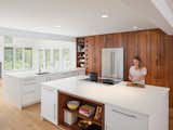 Clean and open kitchen using high gloss white in combination with reclaimed American redwood