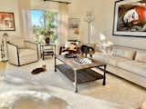 The beanbag chair, Parisian style sofa and chair keep company with White Beggar by humanitarian photographer Lisa Kristine, and a Sicilian Moro head. Rococo chandeliers and African currency accessorize the space. The Bengal cats aren't interested.