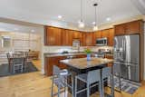 Kitchen, Drop In Sink, Pendant Lighting, Range, Medium Hardwood Floor, Refrigerator, Microwave, and Ceiling Lighting Kitchen and dining.  Photo 11 of 15 in Tavern House by Debra LaPorte Communications