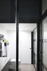 Bath Room, Concrete Floor, Ceramic Tile Wall, One Piece Toilet, Open Shower, Ceiling Lighting, and Wall Lighting the minimalist bathroom and laundry room.  Photo 11 of 17 in Hauteville street residence by Julebourg