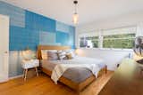Comfortable-sized master bedroom with a hand-painted feature wall in teals and blues is the perfect retreat.