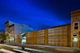 The Wyckoff Exchange, forged from two abandoned warehoused in Bushwick, Brooklyn transforms 10,000-square-feet into a compelling retail venue with a shockingly modest budget. A trademark façade is created with simple awning-style warehouse doors that are clad in double layers of weathered corten steel. The panels are laser-cut with a dynamic gradient pattern and internally illuminated by concealed LED lighting to create a dramatic building facade. The Wyckoff Exchange defines this ever-evolving neighborhood, and has become an icon in its own right. Our practice, founded on the principles of experimentation and pragmatism, produces architecture that is bold and completely transformational.