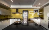 The yellow wall tiles in the kitchen were custom hand-made with glass and applied with enamel. They present a different sparkling and mirror effect which meets the expectations of the female owner for a modern atmosphere.