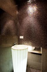 The costume made self illuminated basin, surrounded by shinny bronze tiles.