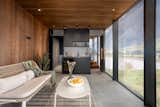 A lounge area with panoramic views of the sea, a kitchenette with a wine fridge
