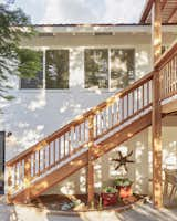 The home was repainted a bright, classic white, which contrasts beautifully with the deep redwood hues. Orlando Soria chose colorful pots and outdoor accessories to further brighten and modernize the space. Photo credit: Zeke Ruelas