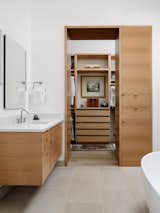 View of Principal Closet From Principal Vanities: Warm Woods, Lueders Limestone and White Surfaces Characterize this Modern Bathroom.