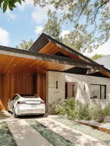 Exterior, Metal Roof Material, Stone Siding Material, Shed RoofLine, Stucco Siding Material, and House Building Type Oblique View of Front Facade: Hemlock Soffits and Cedar Carport Walls Complement a Limestone Entry   Photo 14 of 16 in 15 Modern Carport Ideas from Ramsey Residence