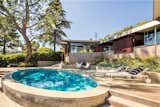 Outdoor, Stone Patio, Porch, Deck, Shrubs, Large Patio, Porch, Deck, Small Pools, Tubs, Shower, Stone Fences, Wall, Retaining Fences, Wall, Raised Planters, Back Yard, and Trees  Photos from A Los Angeles Midcentury Time Capsule by A. Quincy Jones Lists for $3M
