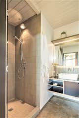 Vertical tiles line the shower and the faucet backsplash.