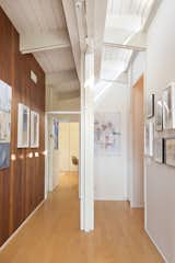 A hallway extending from the kitchen leads to the main structure's three bedrooms and three bathrooms. Clerestory windows illuminate the space from above.